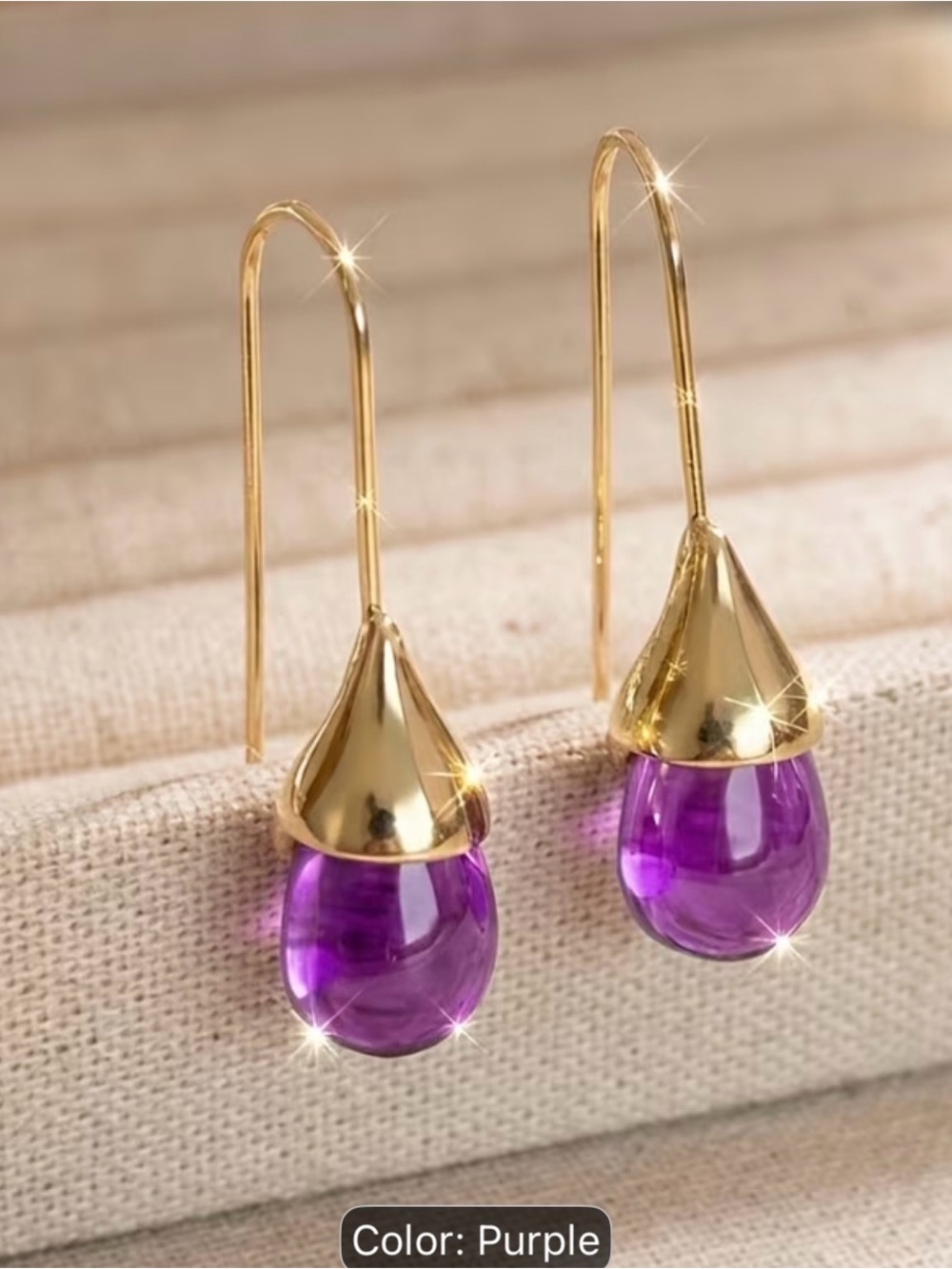 New earrings featuring a teardrop-shaped purple stone with gold-tone hardware